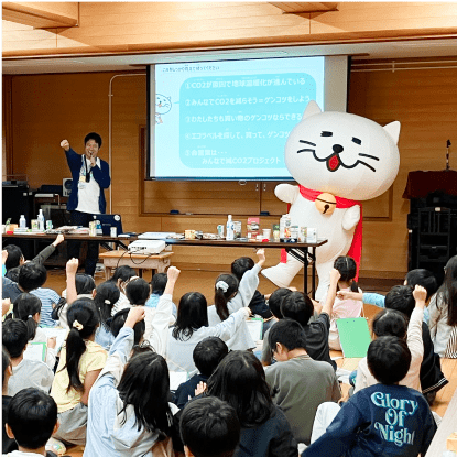 多くの小学生の前で出前授業を行う着ぐるみニャートラル