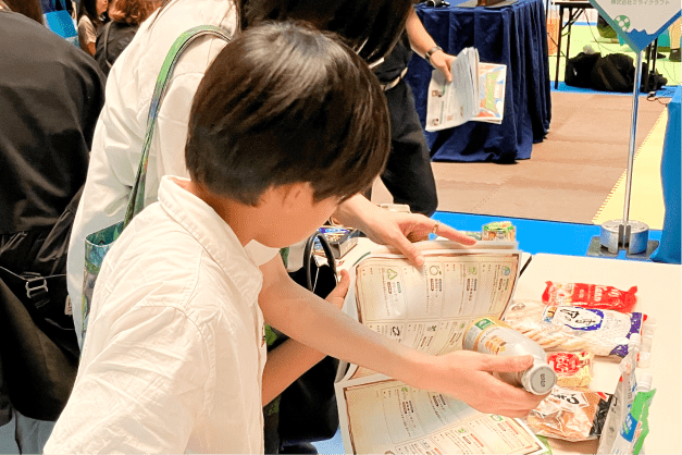 実際の商品に触れながら親子でエコラベルを調査する様子