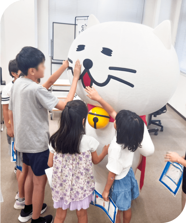 着ぐるみのニャートラルと触れ合う子供たち