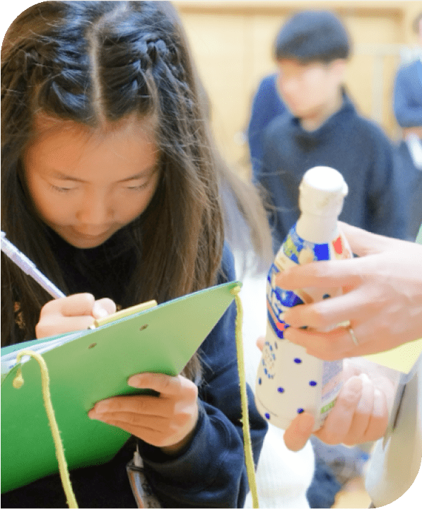エコラベルがついた商品とメモを取る子供